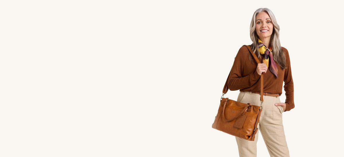 Woman carrying the Alma shoulder bag in Warm Caramel